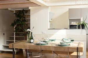 Un comedor con una mesa de madera con sillas de cristal. en Apartment in the old town of Como - MonicaComoApartment, en Como