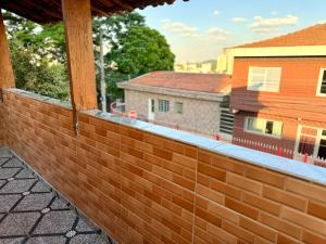 a brick fence on a balcony of a house at AirComfort Stay - 15min Aeroporto Internacional de Guarulhos in Guarulhos