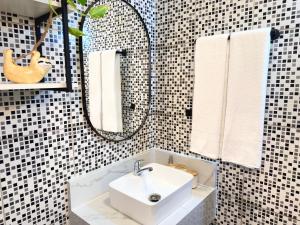 a bathroom with a white sink and a mirror at AirComfort Stay - 15min Aeroporto Internacional de Guarulhos in Guarulhos