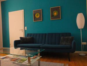 a living room with a blue couch and a table at Fewo Augusta in Tangermünde