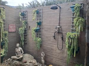 a man sitting on a rock in front of a shower at Listening Wind Self-Catering accommodation in Bettyʼs Bay +73 photos
