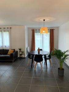 a living room with a table and a couch at 5mn Crolles Chambre au calme parking gratuit - belle cuisine partagée in Froges +19 photos