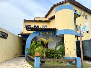 a house with a blue arch in front of it at Pousada Orla do Sol in Prado