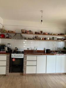 eine Küche mit weißen Schränken und einem Herd mit Backofen in der Unterkunft Casa Quinta Arroyo del Medio in Acindar