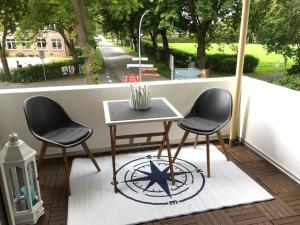 two chairs and a table on a balcony at Fehmarn Oase in Petersdorf auf Fehmarn