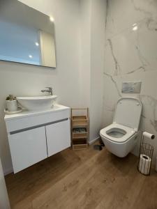 a white bathroom with a sink and a toilet at Aver Beach Haven in Póvoa de Varzim +11 photos