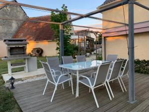 un patio avec une table, des chaises et un barbecue dans l'établissement Maison familiale Centre France, à Meunet-sur-Vatan