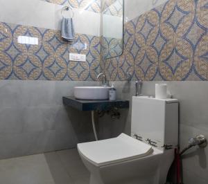 a bathroom with a toilet and a sink at Rovers Suites - 2BHK Entire Luxury Apartment in Mussoorie +30 photos