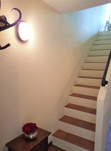 a staircase in a house with a table and flowers at "Vista dolce" in Brissago