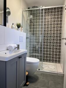 a bathroom with a toilet and a shower curtain at Haus Strandherz Hausteil Steuerbord in Utersum