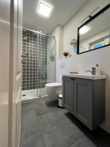 a bathroom with a toilet and a sink and a shower at Haus Strandherz Hausteil Backbord in Utersum