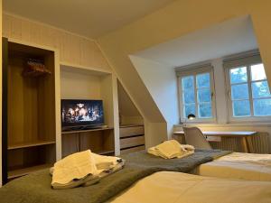 a bedroom with two beds and a tv in it at Haus Strandherz Hausteil Backbord in Utersum