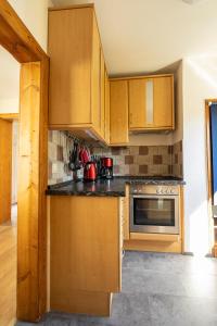 a kitchen with wooden cabinets and a stove at Ferienhaus Zum Waldrand in Erfweiler
