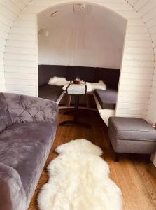 una sala de estar con un sofá y una mesa en Tirolian Lodge East, en Bundorf