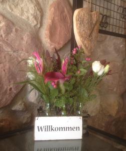 un jarrón con flores en él sentado en una mesa en "Heideroses's", en Altenburg