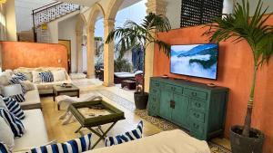 a living room with a television on a wall at Casa Zarah - Alma Hotels in Santa Marta