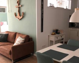 una sala de estar con un sofá y una mesa en Kellenhusen Tor Ankerplatz, en Kellenhusen