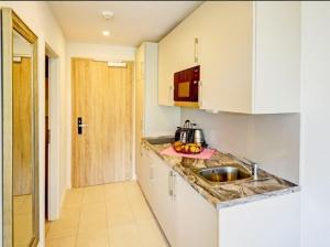 a kitchen with white cabinets and a sink at Apartment Sonnendeck in Ulstrupfeld