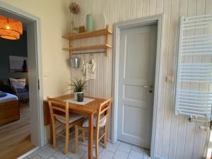 a dining room with a wooden table and a door at Haus AchternDiek Strandhafer in Dahme