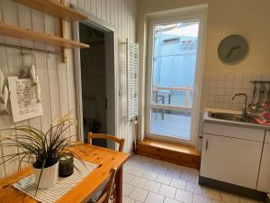 a kitchen with a table and a sink and a window at Haus AchternDiek Strandhafer in Dahme