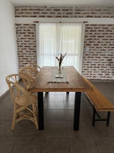a wooden table with chairs and a vase of flowers on it at Salir del Cráter Apart VALENTIN in Los Sarmientos