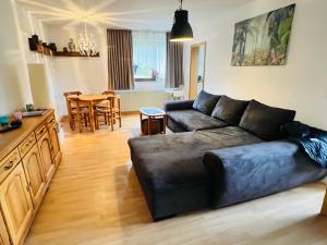Una sala de estar con un sofá negro y una mesa. en Ferienwohung Arnstein Nr 2, en Waldeck