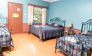 a bedroom with two beds and blue walls at Brackenhurst Hotel and Conferences in Limuru
