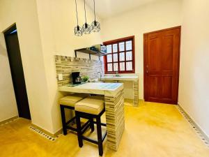 a kitchen with a counter and stools in a room at Casa Petra en Chichén Itzá in Pisté