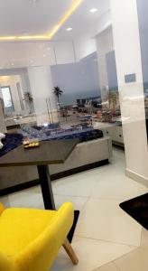 une chaise jaune assise à côté d'une table dans une pièce dans l'établissement Beach Front Apartments I, à Lagos 4 autres photos