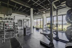 a gym with a large room with equipment and windows at Salt City Penthouse in Salt Lake City