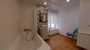 a bathroom with a tub and a sink and a chair at Chez ELLE in Oraison +70 photos