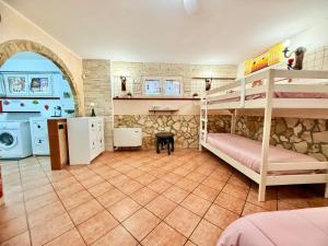 a bedroom with two bunk beds and a kitchen at OPEN SPACE Littoria in Latina