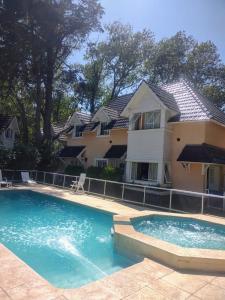 a house with a swimming pool in front of a house at Lahuen-co Paraje de Mar in Valeria del Mar