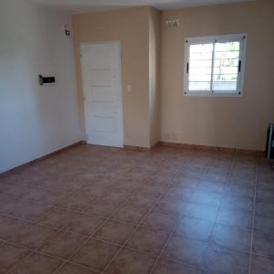 an empty room with a door and a tiled floor at Lihuel 1 AG in Alta Gracia