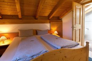 a large bed in a room with wooden ceilings at Abendruh -566- in Krün +7 photos