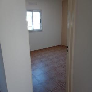 an empty room with a window and a tile floor at Lihuel 1 AG in Alta Gracia