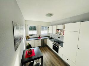 a kitchen with white cabinets and a table in it at Fewo Elke in Barsinghausen