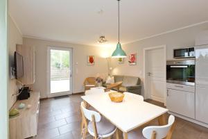 eine Küche und ein Wohnzimmer mit einem weißen Tisch und Stühlen in der Unterkunft Stieglitz Nest in Marienfelde