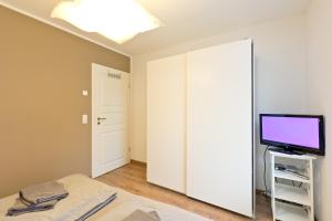 ein Schlafzimmer mit einem Spiegel, einem TV und einem Bett in der Unterkunft Stieglitz Nest in Marienfelde