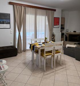 a dining table and chairs in a living room at H&H cozy retreat ,Fireplace and Parking in Piraeus