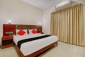 a bedroom with a large bed with red pillows at Super Townhouse Kizhakkambalam Tourist Home in Cochin +57 photos