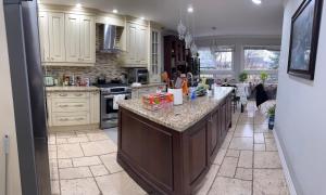 a kitchen with white cabinets and a large island at 4人双床房 in Mississauga