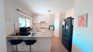 a kitchen with a sink and a refrigerator at Cozy comfortable House in Mildura