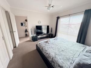 a bedroom with a bed and a large window at Cozy comfortable House in Mildura