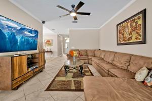 a living room with a couch and a flat screen tv at 11326 CYPRESS TRAIL DRIVE ORLANDO 3BED in Orlando