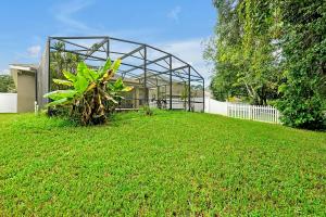 a green house with a plant in the yard at 11326 CYPRESS TRAIL DRIVE ORLANDO 3BED in Orlando +54 photos