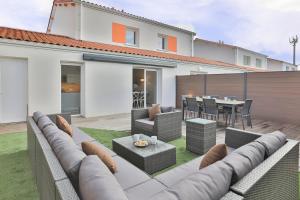 a patio with a couch and a table in a house at SéjourOlonne - Maison para-hôtellière 4 étoiles, quartier calme in Les Sables-dʼOlonne