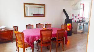 a dining room with a table and chairs and a fireplace at La Maison du Livradois in Beurrières