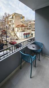 a table and chairs on a balcony with a view at Daisy Rooms City Centre in Tirana