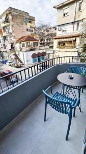 a table and chairs on a balcony with a view at Daisy Rooms City Centre in Tirana +25 photos